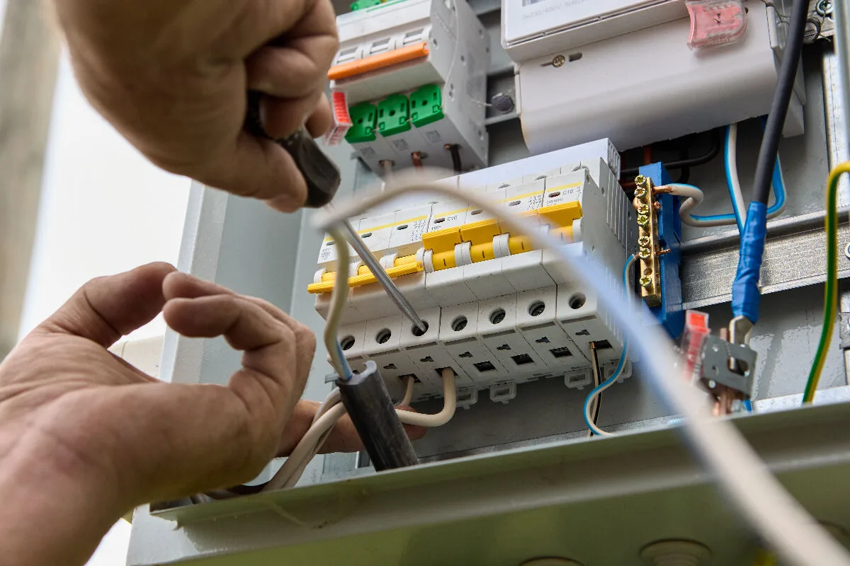 Electrician working inside a breaker panel