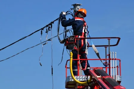 Lineman working from a bucket truck on overhead power lines
