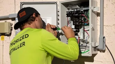 Technician servicing an outdoor electrical panel